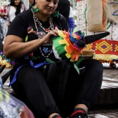 Mujer indígena elaborando artesanía 