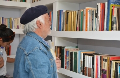 Adulto viendo libros en una estantería 