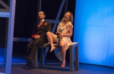 Actores  sonriendo sentados sobre una mesa.