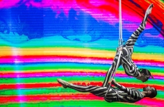 Malabaristas con traje tipo cebra sobre fondo multicolor en el escenario