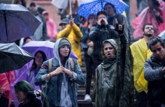 Público disfrutando del espectáculo bajo la lluvia.
