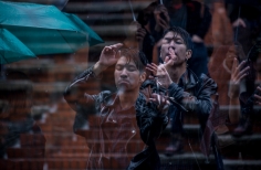 Dos hombres disfrutando del espectáculo bajo la lluvia.
