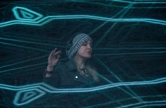 Mujer con proyecciones de luz sobre el escenario