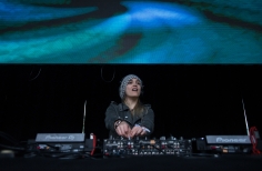 Mujer manejando una consola en el escenario de la Media Torta