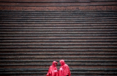 Dos personas con capotas impermeables en las graderías de la Media Torta