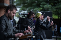 Hombre cantando y músicos en el escenario