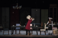 Mujeres en escena alrededor de una mesa 