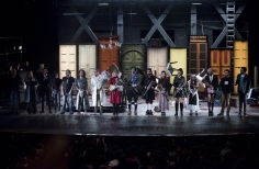 Grupo de actores al final de la obra recibiendo aplausos y flores.