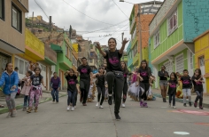 Grupo de bailarines recorriendo una calle