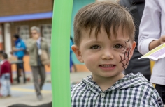 Niño con telaraña pintada en su cara, sonriendo 