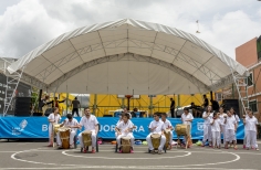 Grupo de  jóvenes y niños artistas con instrumentos en actividad al aire libre