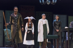 Grupo de actores en el escenario con diferentes vestimentas