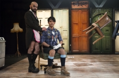 Hombre vestido de empleada doméstica y hombre vestido de niño con pantalones cortos