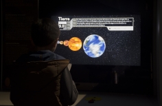 Niño interactuando con expoisición de pantalla