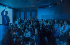 Grupo de personas recibiendo información de un funcionario del Planetario 