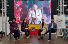 4 personas sentadas en la tarima de la sala Nencatacoa, donde se lanzó la exposición virtual