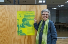 Rosario Caicedo junto a una foto de Andrés Caicedo en Andrés Caicedo: Morir y dejar obra.