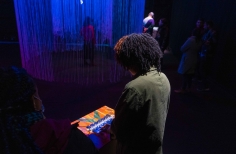 Público interactuando con la Exposición El Beat, con instrumento musical.