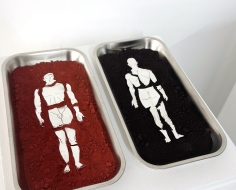 dos contenedores con polvo de color rojo y negro y una figura humana en blanco en cada uno 
