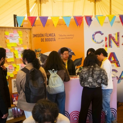 Público y miembros de la Cinemateca de Bogotá disfrutando e informando en el stand durante el BAM 2025