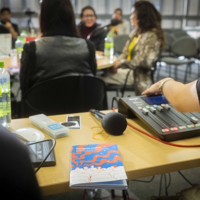 Guía gritemos corte en una mesa mientras los invitados y moderadores charlan al rededor del contenido de la Guía durante el BAM 2025