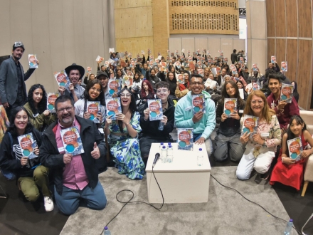 Un grupo de personas se reunen para mostrar ejemplares de una antología literaria.