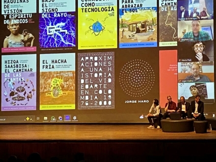 En un escenario se proyecta una pantalla en el que un panel expone las publicaciones realizadas por la Línea ACT del idartes. El escenario hace parte de la programación de la vigesimo cuarta edición del Festival de la Imagen en Manizales.