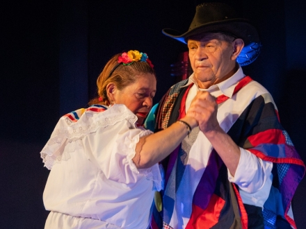 dos personas mayores bailan en un escenario