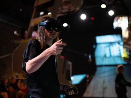 Un hombre usa un visor de Realidad Aumentado en el salón donde se desarrolló ÁGORA: laboratorio de teatro VR y dramaturgias inmersivas.