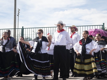 Un grupo de personas mayores bailan en un parque