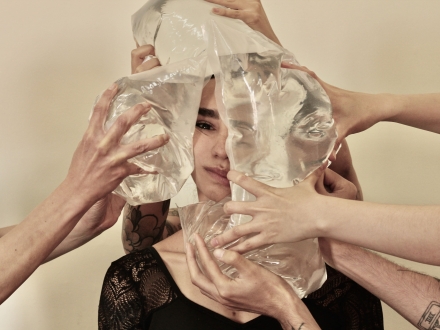 Persona rodeada de muchas manos con bolsas de agua 