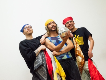 tres hombres posan frente a la cámara