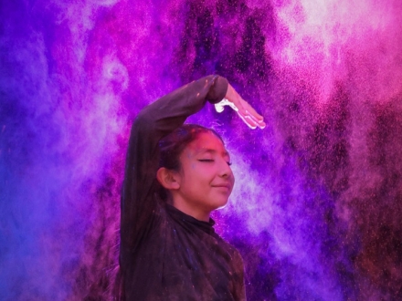 una niña danza en medio de luces de colores