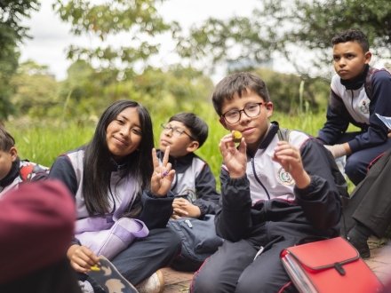 Un grupo de niños en uniforme de colegio, sonrien a la cámara.