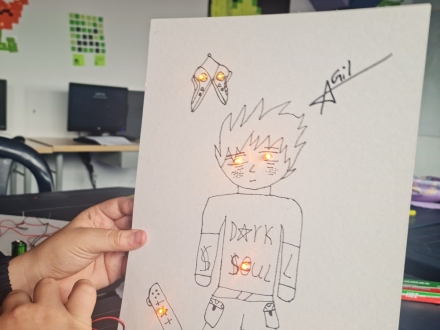 Una persona sostiene un dibujo con circuitos