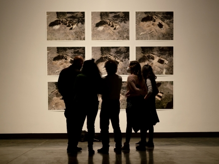 Personas ven una serie de fotografías en la Galería Santa Fe. Foto: Mónica Torregrosa / Idartes.