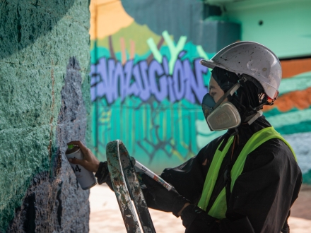 Mujer artista hace una intervención con pintura en la Zona Bajo Puente de la 170. Foto: Kadir Molano / Idartes.