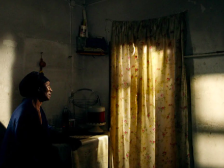 mujer afro mirando hacia una ventana