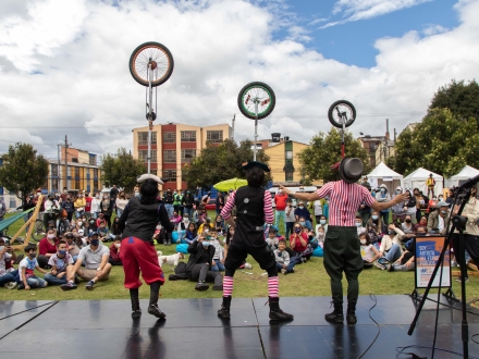 Tres artistas circenses actúan frente al público. 