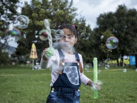 Niña jugando al aire libre con bombas de jabòn