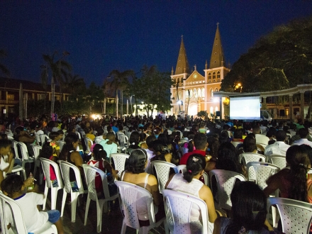 personas sentadas en un parque viendo cine 