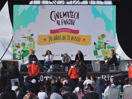 Personas en conversatorio después de ver una película al aire libre 