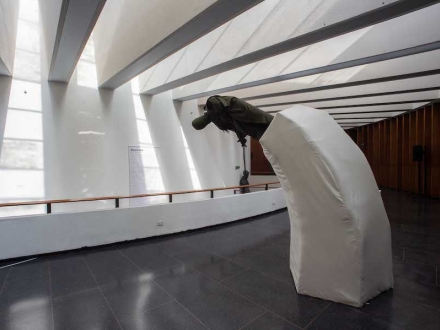 Estatua inclinada hacia un lago en el pasillo del Planetario de Bogotá. 