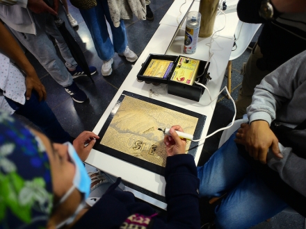 Integrantes de Fuego Joven realizando pirograbado sobre una tabla de madera. 