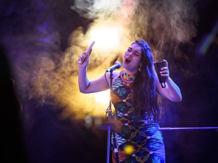 Mujer cantando en un escenario. 