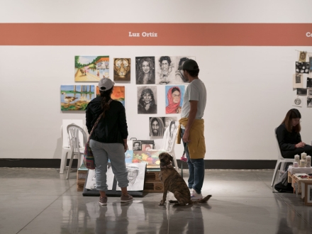 Pareja y perro observando los puestos de los artistas de las FLA en La Galería Santa Fe