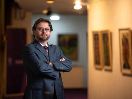 Carlos Mauricio Galeano con galería de fondo a media luz. 