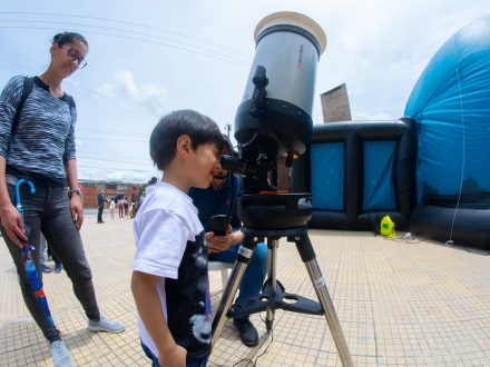 Personas observando por telescopio.
