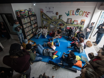 Grupo de personas reunido en una biblioteca de día.