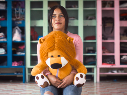 Niña con un peluche de león en la mano 